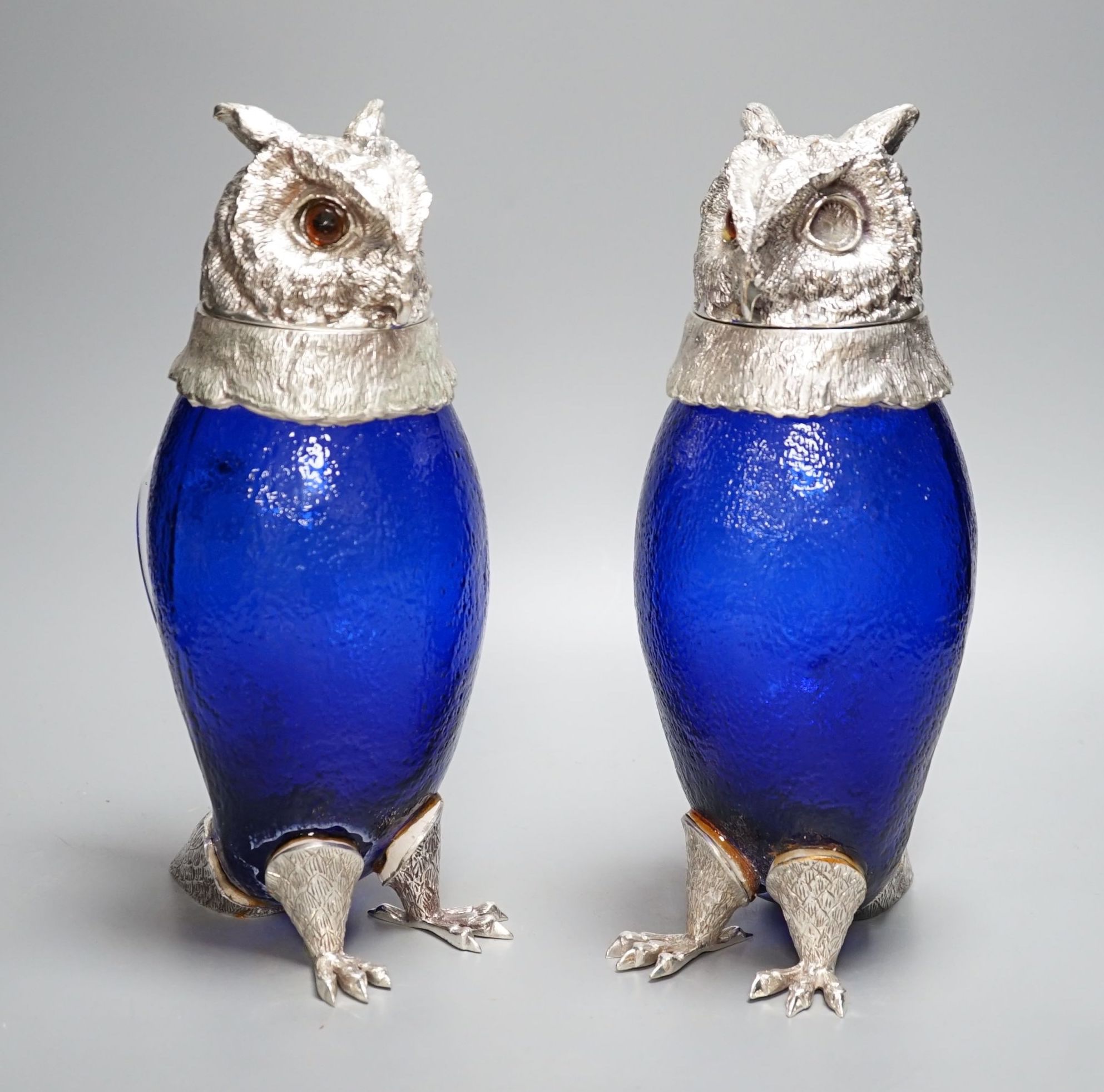 A pair of modern silver plated and blue glass novelty owl flasks, 28.5 cms high.